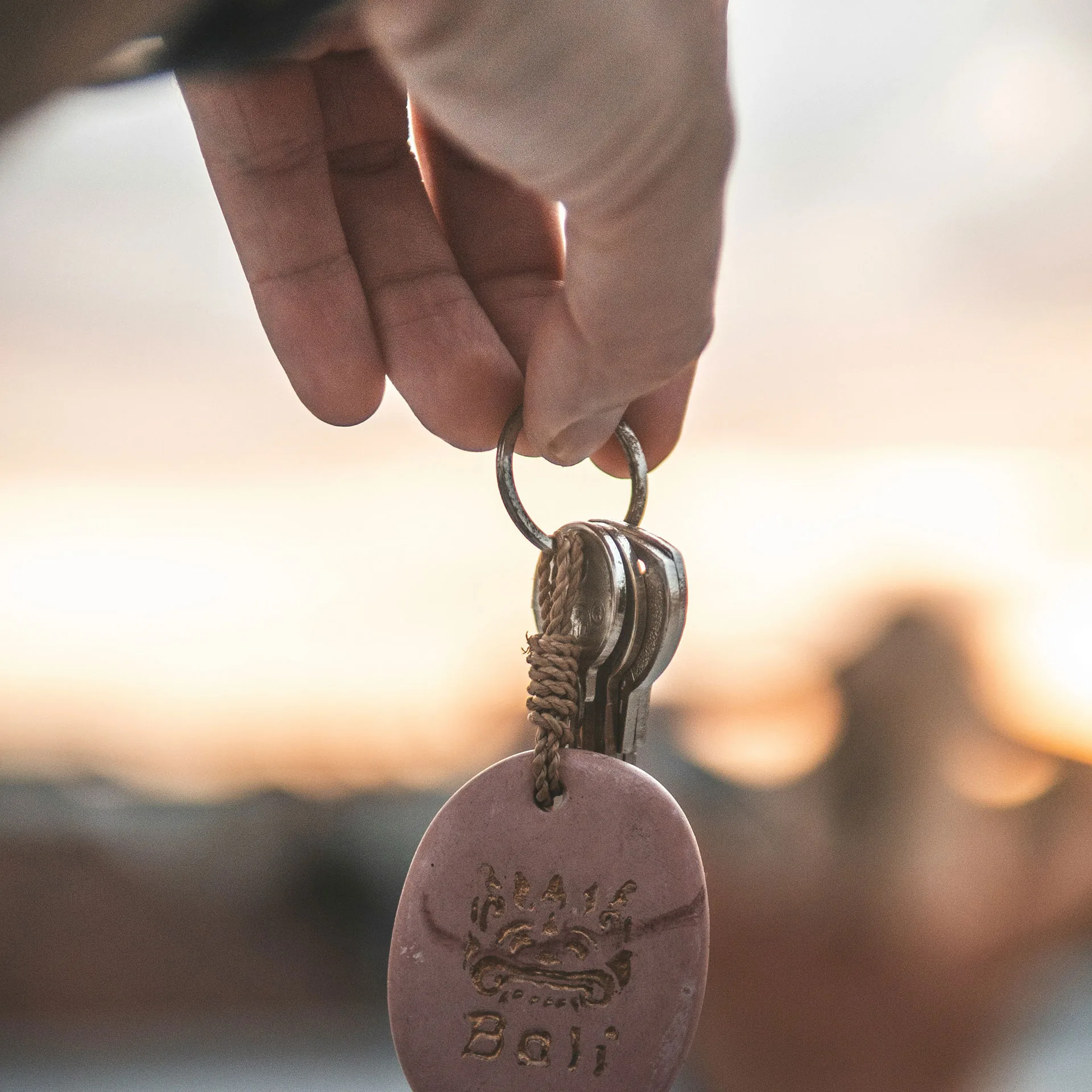 Händer som håller i nyckel med himmel i bakgrunden